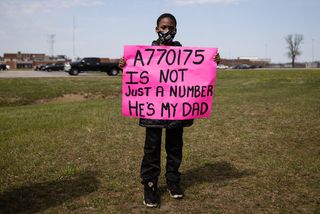 The son of an inmate holds a sign outside the Marion Correctional Institution in Ohio