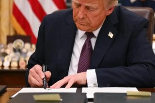 US President Donald Trump signs an executive order regarding Department of Government Efficiency (DOGE), in the Oval Office of the WHite House in Washington, DC, on January 20, 2025