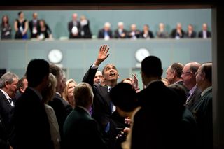 President Barack Obama waves to people in the gallery after addressing the Australian Parliament in the House of Representatives at Parliament House in Canberra, November 2011