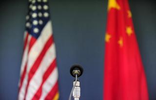 The US and China flags behind a microphone, Beijing