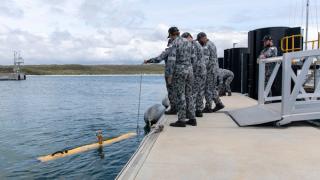 Royal Australian Navy sailors conduct ballast checks on the Bluefin-9 autonomous underwater vehicle before an exercise in Jervis Bay