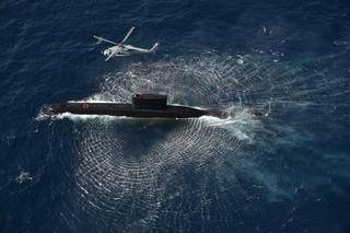 Indian Navy MH-60R Seahawk helicopter operating with an INS Shishumar-class submarine.