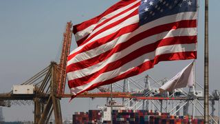 US flag flying at a shipping container port