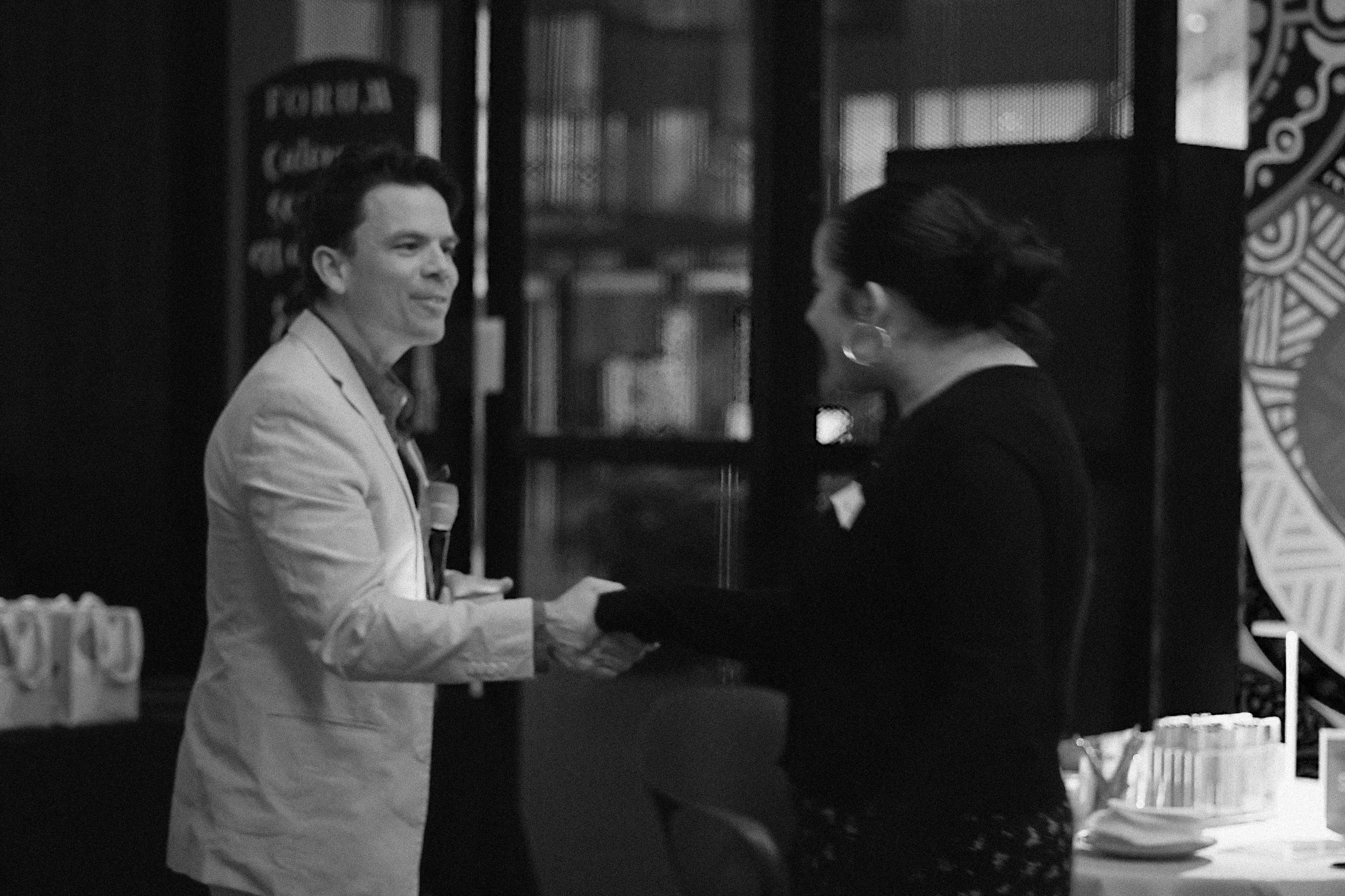 Person shaking hand with a student receiving a prize.