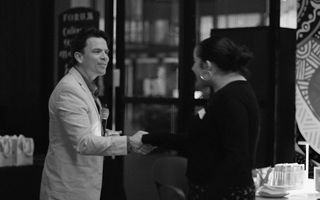 Person shaking hand with a student receiving a prize.