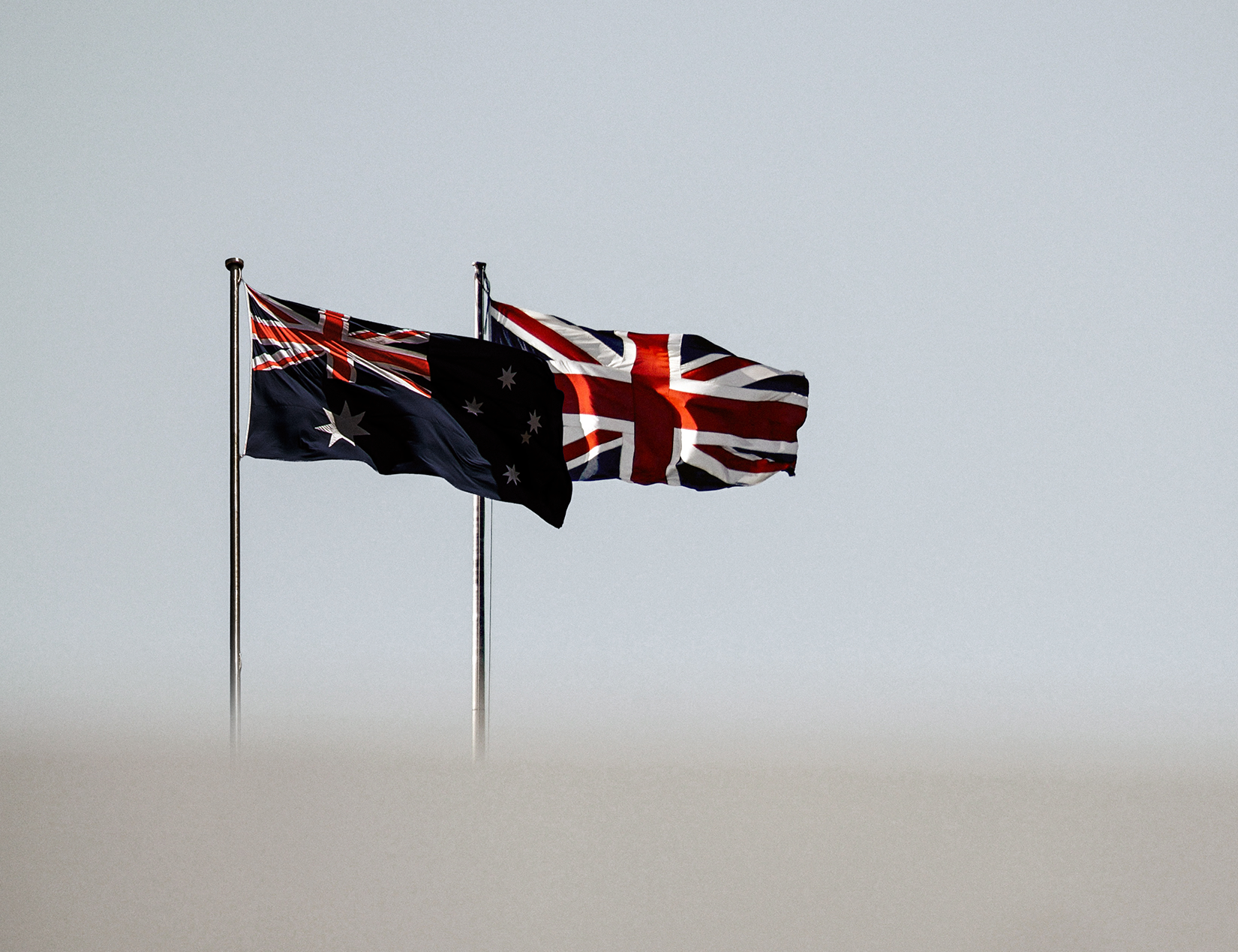 Australian and UK flags in the wind.