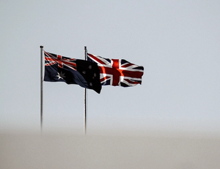 Australian and UK flags in the wind.