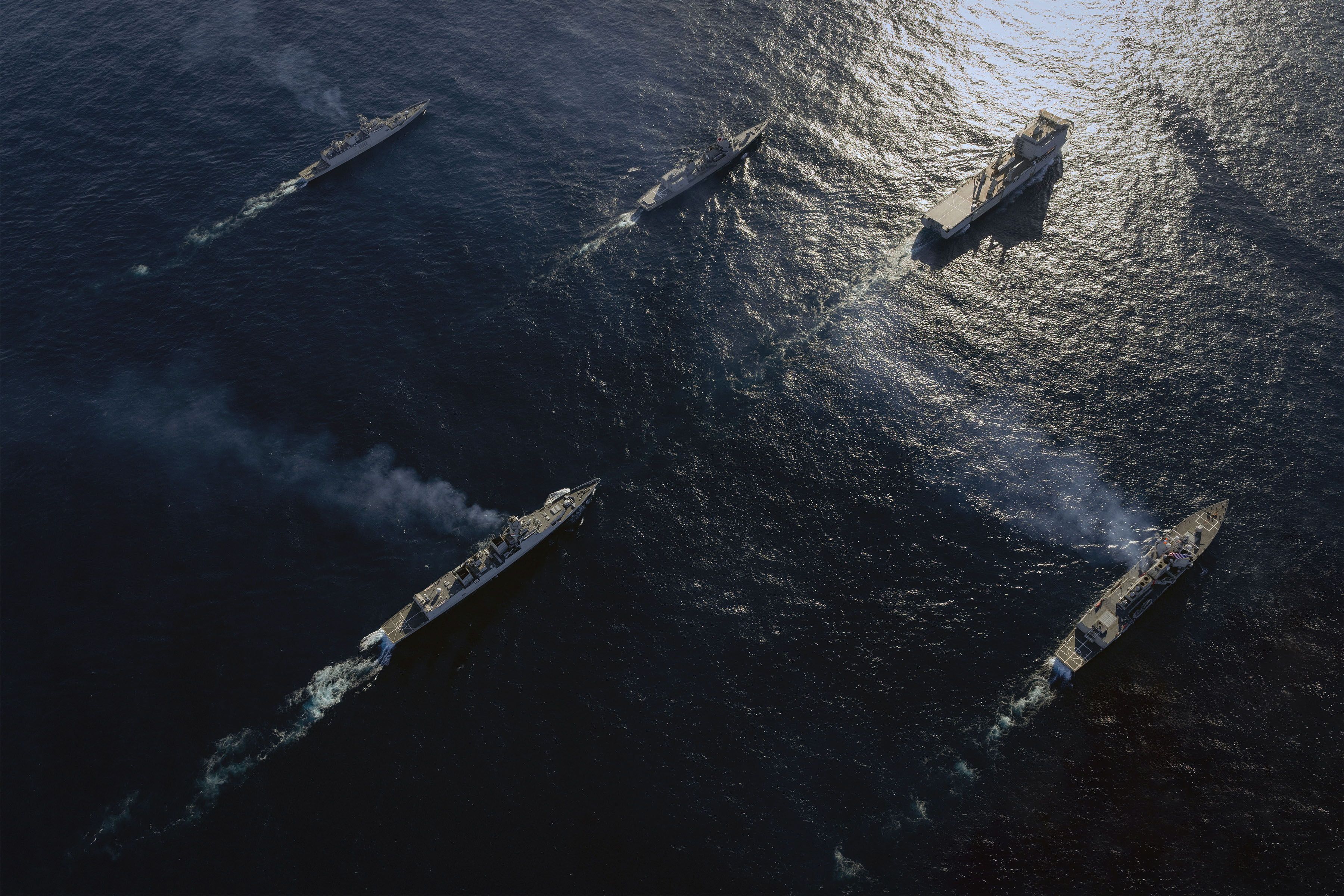 Multiple warships sailing in the ocean