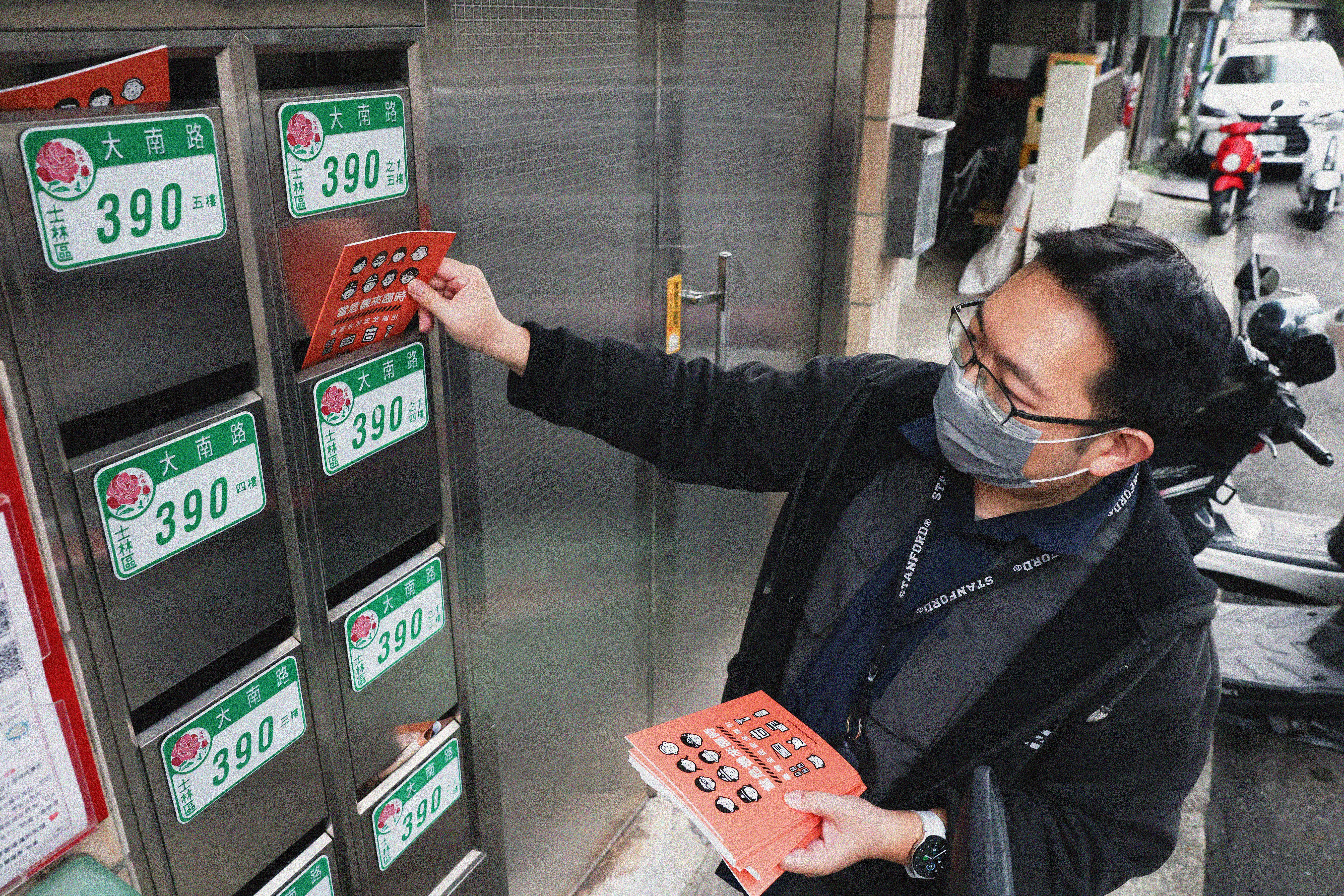 A person putting brochures in letter boxes.