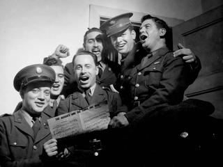 US ‘doughboys’ whoop it up with Australian soldiers in a community sing at the American Red Cross Service Club, circa 1942