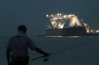 A man fishes in front of a liquefied natural gas (LNG) tanker berthed at a gas fired thermal power plant in Futtsu, Chiba Prefecture, Japan.
