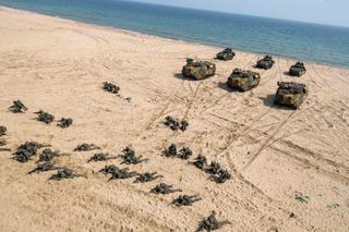 US and Republic of Korea soldiers and vehicles on the shore of a beach conducting an amphibious assault during Exercise Ssang Yong in 2023