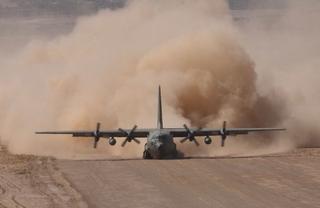 A RAAF C-130 Hercules lands on a dirt strip at a forward operating base in Afghanistan to resupply the Australian Special Forces Task Group Operations during Operation Slipper, 2005