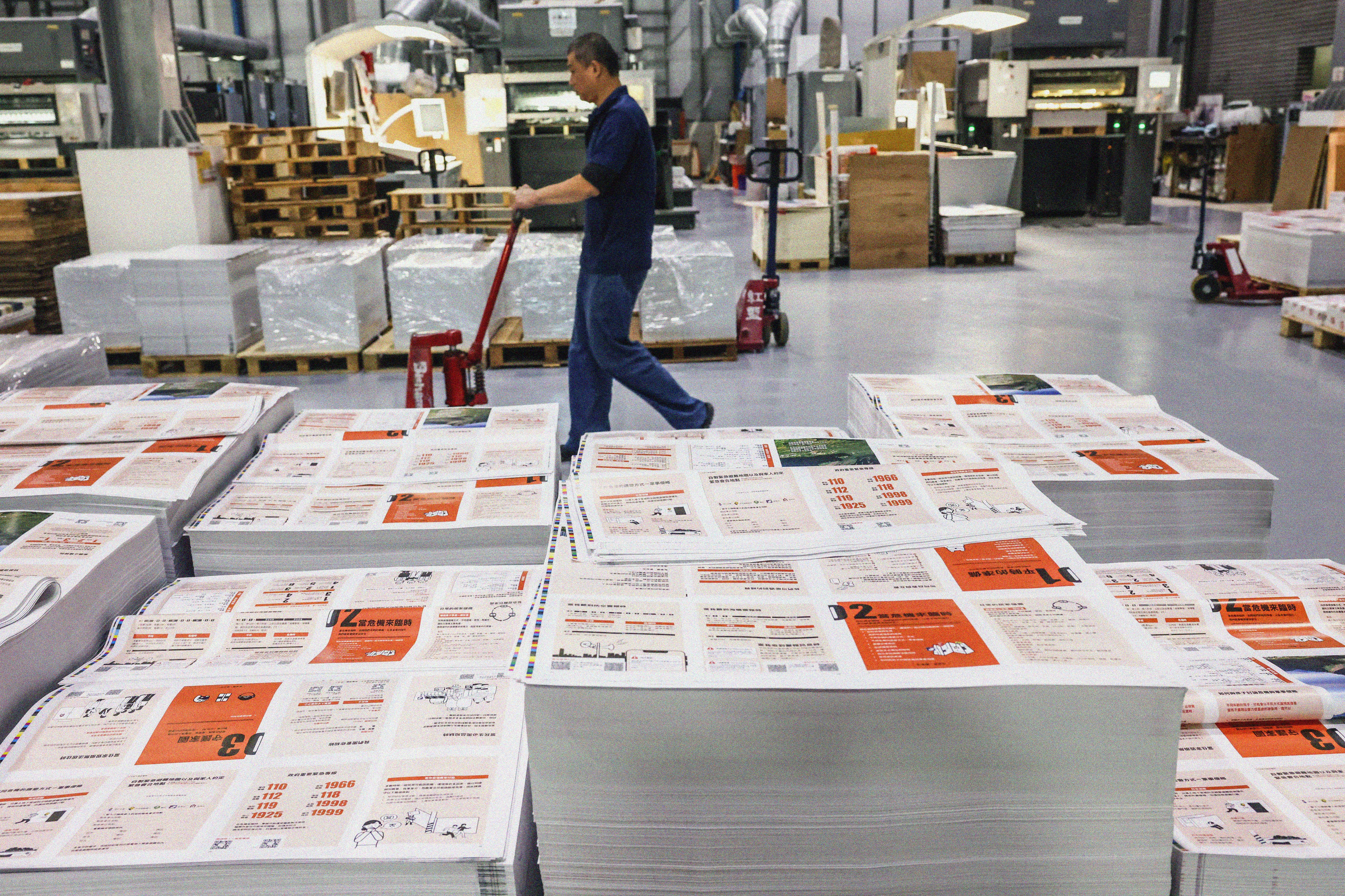 Brochures stacked on a factory floor.