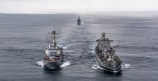 A US Arleigh Burke-class destroyer sails alongside a Chilean replenishment ship at exercise Teamwork South (July 2019)