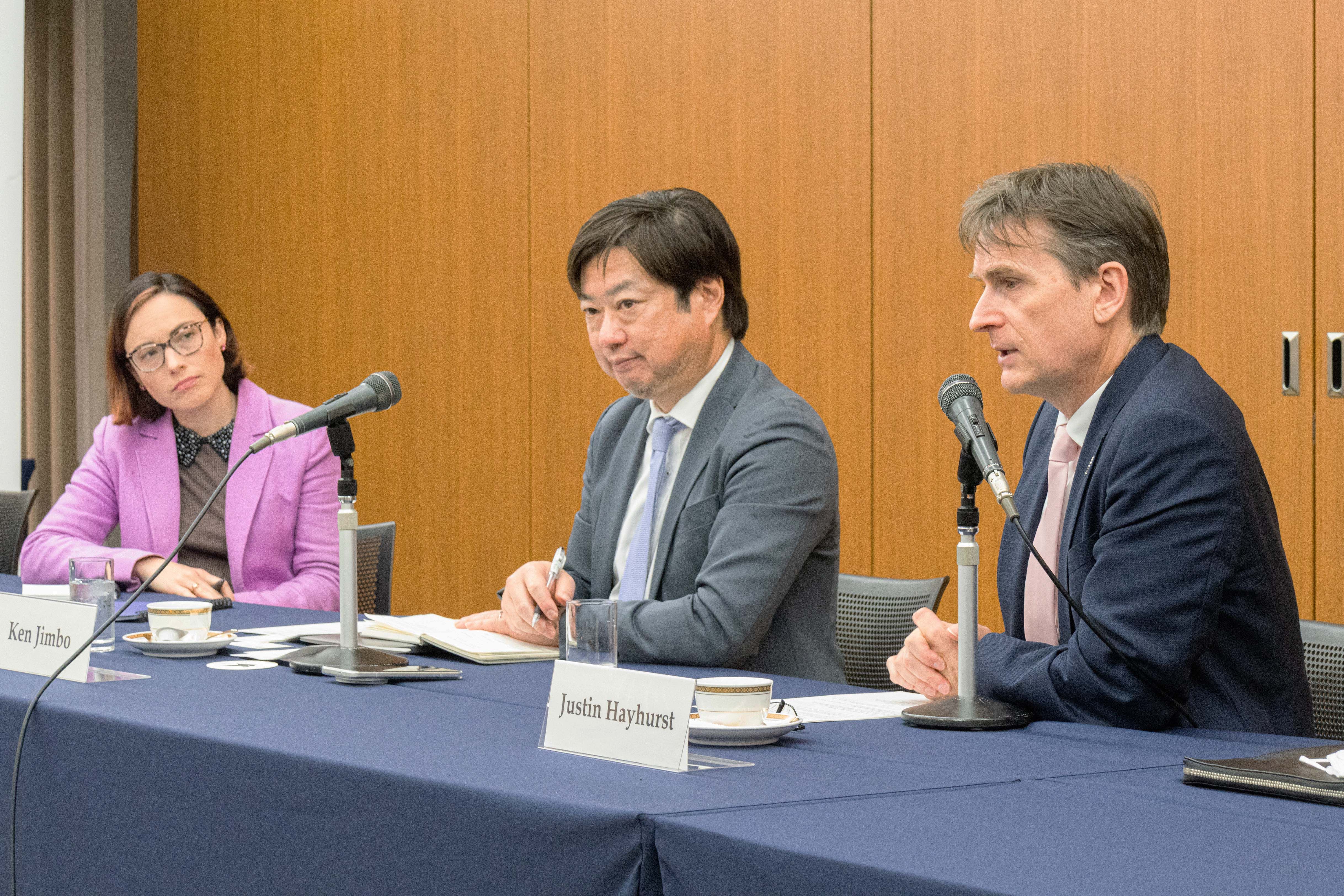 Three people in a discussion at a table.