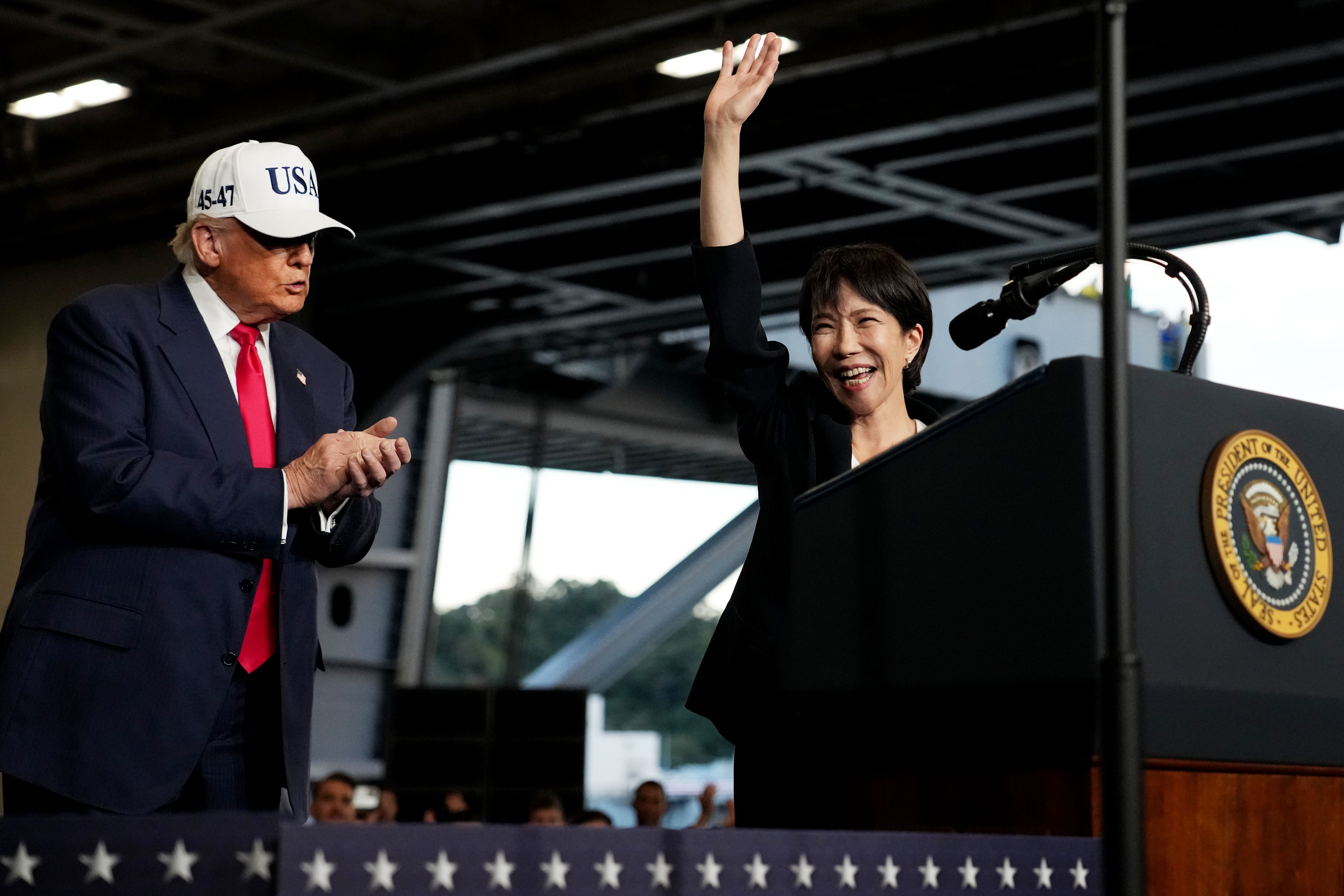 U.S. President Donald Trump applauds as Japanese Prime Minister Sanae Takaichi speaks to troops aboard USS George Washington at Fleet Activities Yokosuka on October 28, 2025 in Yokosuka, Japan. Trump is visiting Japan, fresh off an appearance at the ASEAN summit in Malaysia, and will next travel to South Korea for the APEC meetings. 