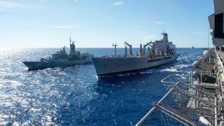 The fleet replenishment oiler USNS Rappahannock refuels the amphibious assault ship USS Bonhomme Richard and the Royal Australian Navy frigate helicopter HMAS Anzac during a replenishment-at-sea