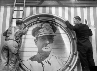 Staff of Melbourne’s Myer Emporium hang a portrait of General Douglas MacArthur, Commander in Chief, South West Pacific Area, in preparation for American Independence Day in 1943