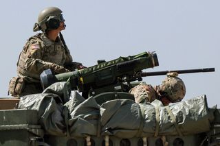 A person operating a large weapon during a training exercise.