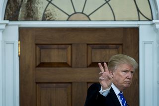 President-elect Donald Trump gives the peace sign after his meeting with Betsy DeVos at Trump International Golf Club, November 19, 2016 in Bedminster Township, New Jersey.