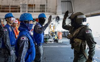 Royal Australian Navy sailor Leading Seaman Aviation Anthony Hunt from HMAS Toowoomba greets crew members from the Republic of Korean ship Gang Gam — Chan during a cross deck exercise as part of the regional presence deployment 2023