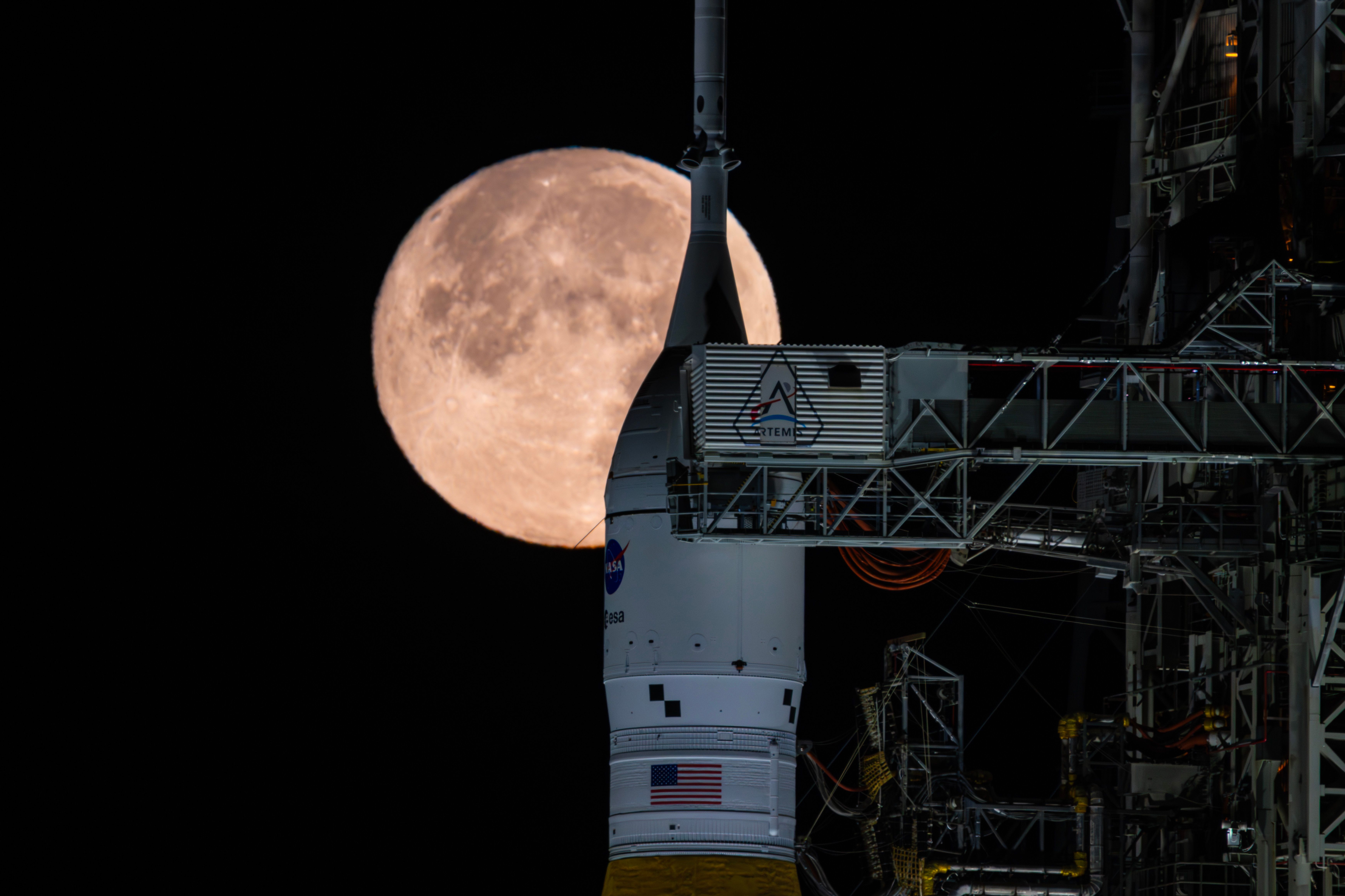 The Moon is seen shining over the SLS (Space Launch System) and Orion spacecraft, atop the mobile launcher on February 1, 2026. The rocket is currently at Launch Pad 39B at NASA’s Kennedy Space Center in Florida, as teams are preparing for a wet dress rehearsal to practice timelines and procedures for the launch of Artemis II.