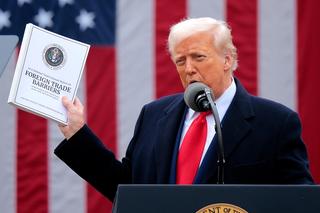 US President Donald Trump holds up a copy of a 2025 National Trade Estimate Report as he speaks during a trade announcement event at the White House, 2 April 2025.