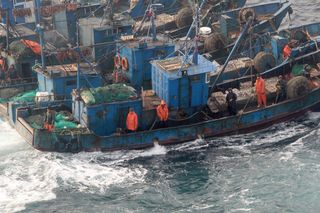 A picture taken from a South Korean helicopter shows fishermen aboard Chinese fishing vessels roped together to thwart an attempt by South Korean coast guard ships to stop their alleged illegal fishing in the Yellow Sea off the coast of South Korea.