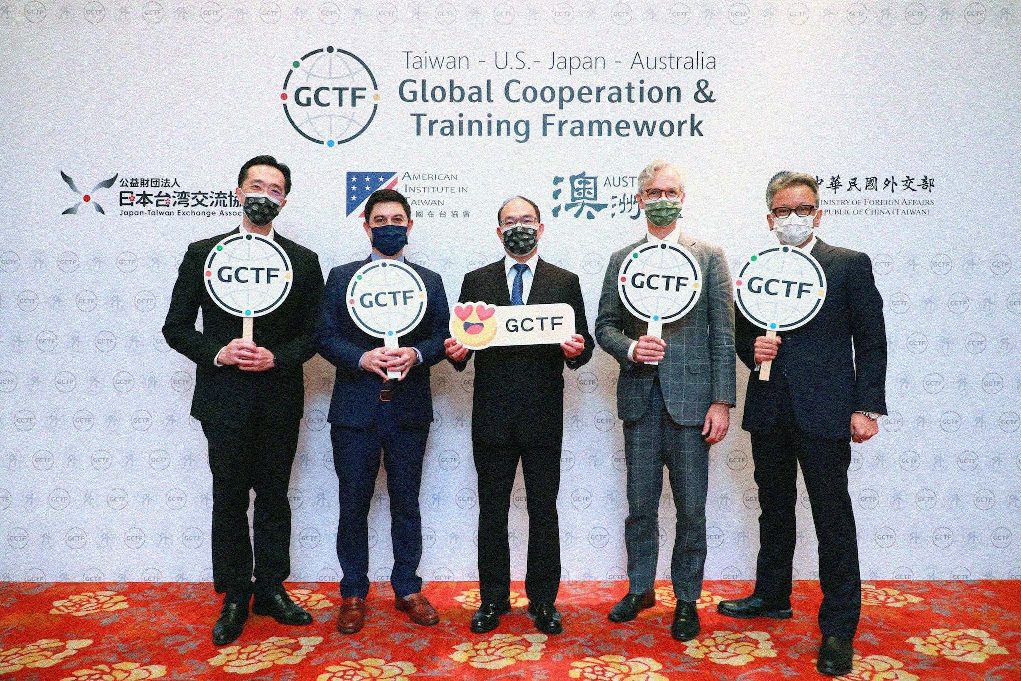 Five people holding up 'GCTF' signs.