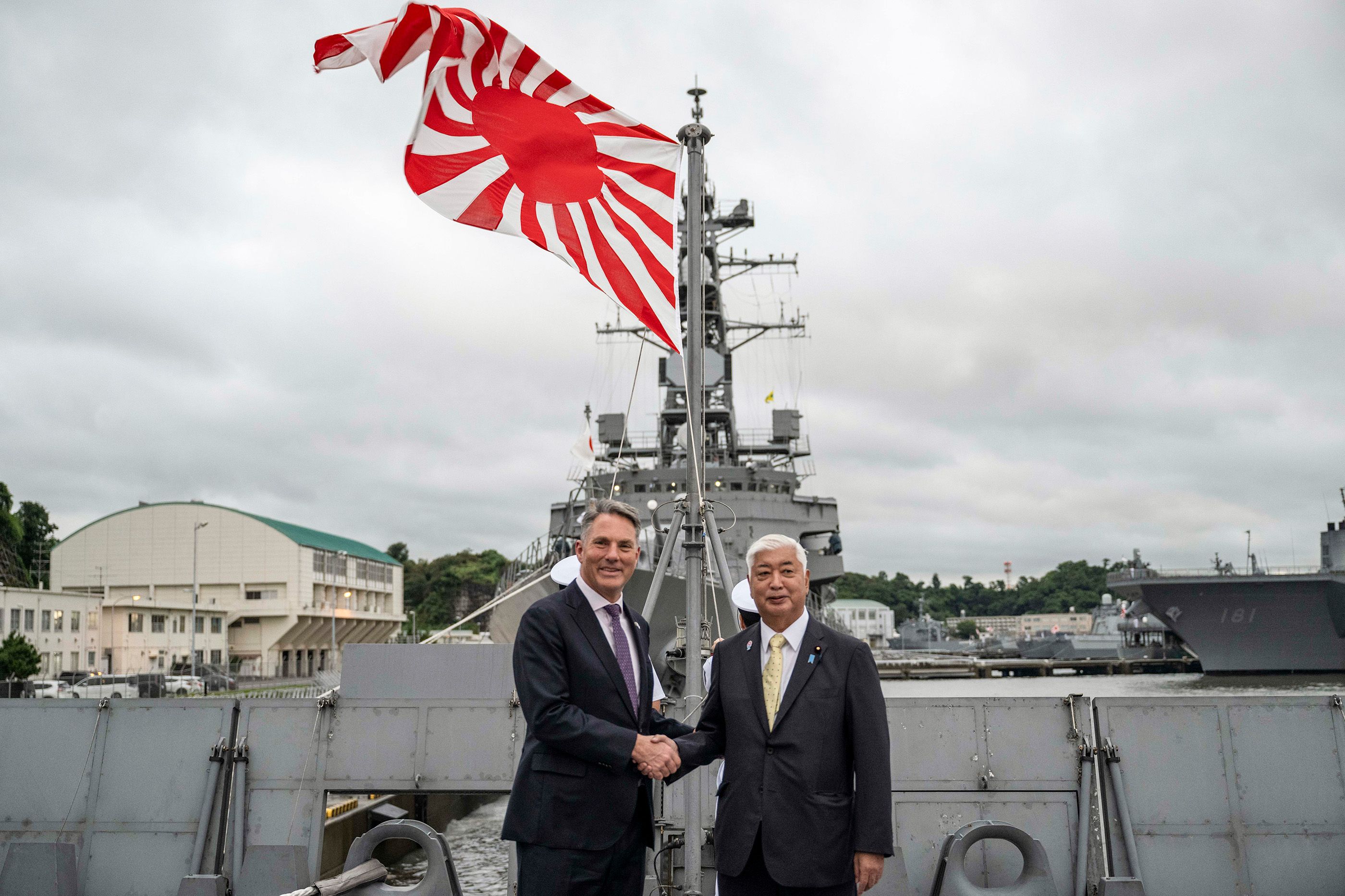 Australia’s Defence Minister Richard Marles and Japan’s Defense Minister Gen Nakatani shake hands ahead of a joint press announcement aboard the Japan Maritime Self-Defense Force Mogami-class stealth frigate in Yokosuka, September 2025. 