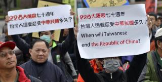 Pro-Taiwan independence activists display signs during the 70th anniversary of the 228 incident in Taipei on 28 February 2017