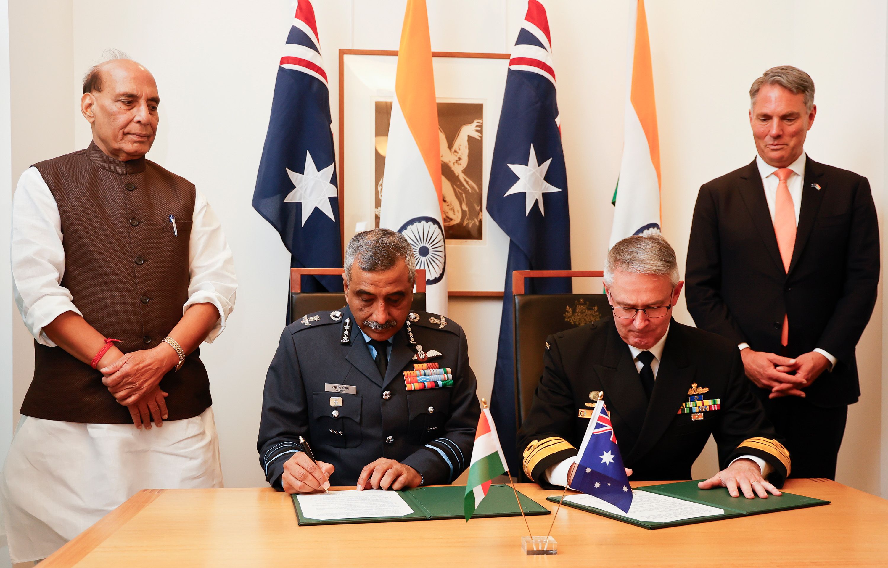  Indian Defence Minister, Shri Rajnath Singh (L) and Deputy Prime Minister and Minister for Defence, Richard Marles (R) witness Vice Chief of the Naval Staff of India, Sanjay Vatsayan (2nd-L) and Australia's Deputy Chief of Navy Matt Buckley (2nd-R) signing defence cooperation documents to Australia for his first official visit on October 09, 2025 in Canberra