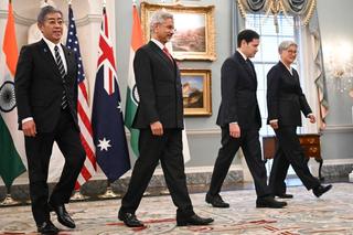 Four Quad ministers walk as a group at a meeting.