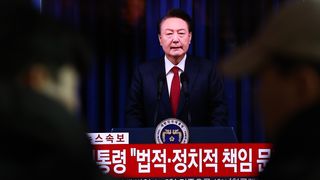 A screens shows footage of South Korean President Yoon Suk Yeol delivering an address to the nation at Seoul station on December 07, 2024 in Seoul, South Korea. South Korea is facing significant political turmoil after President Yoon Suk-yeol declared emergency martial law, accusing opposition parties of destabilizing governance and sympathizing with North Korea.