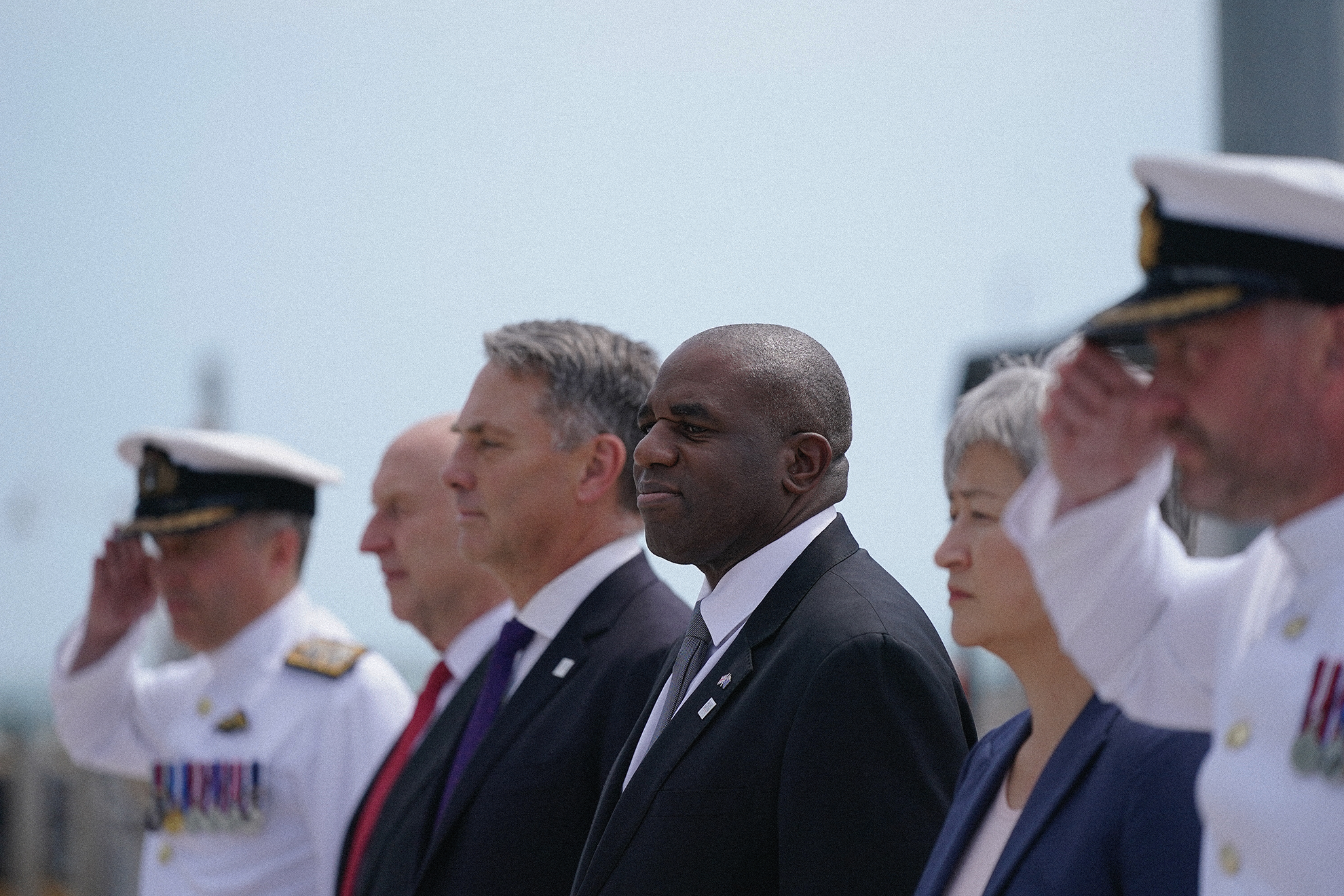 Four ministers stand in a row, with navy officers beside them.