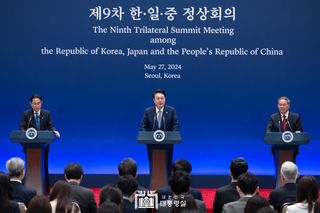 Three leaders from South Korea, China and Japan speaking at the Ninth Trilateral Summit Meeting in 2024