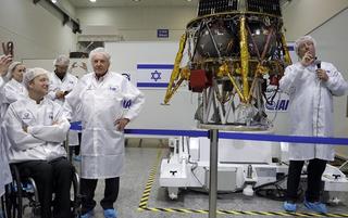 Israeli Aerospace Industries director of Space division Opher Doron (R) and billionaire investor Morris Kahn (2nd-R) present a spacecraft during a press conference to announce its launch to the moon