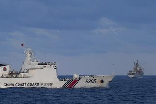 A Chinese Coast Guard ship sails near a Philippine vessel that was part of a convoy of civilian boats in the disputed South China Sea, December 2023