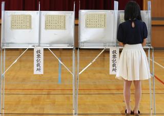 A woman casts her vote for parliament’s upper house election at a polling station in Himeji, Japan, July 2016.