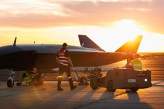 An MQ-28A Ghost Bat is loaded with a NAIM-120 inert air-to-air missile variant at the ordnance loading area during Trial Kareela at RAAF Base Woomera.
