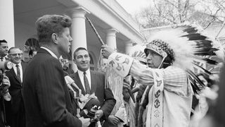President John F. Kennedy is presented a ceremonial pipe by Edison Realbird from the Montana Crow Indian Agency during a visit to the White House by 100 members of the National Congress of American Indians.