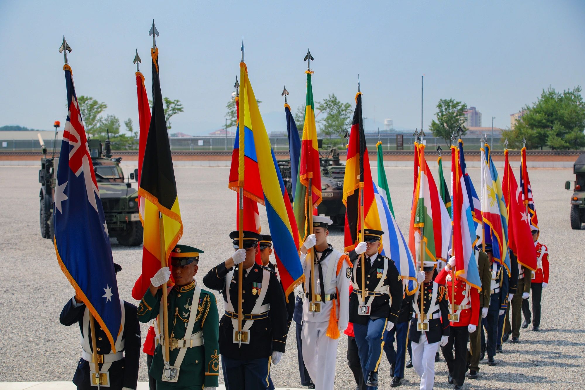 The United Nations Command Honor Guard bears the flags of the 22 nations that came to the aid of the Republic of Korea during the Korean War during the UNC 75th Birthday Ceremony at Barker Field on Camp Humphreys in July 2025.