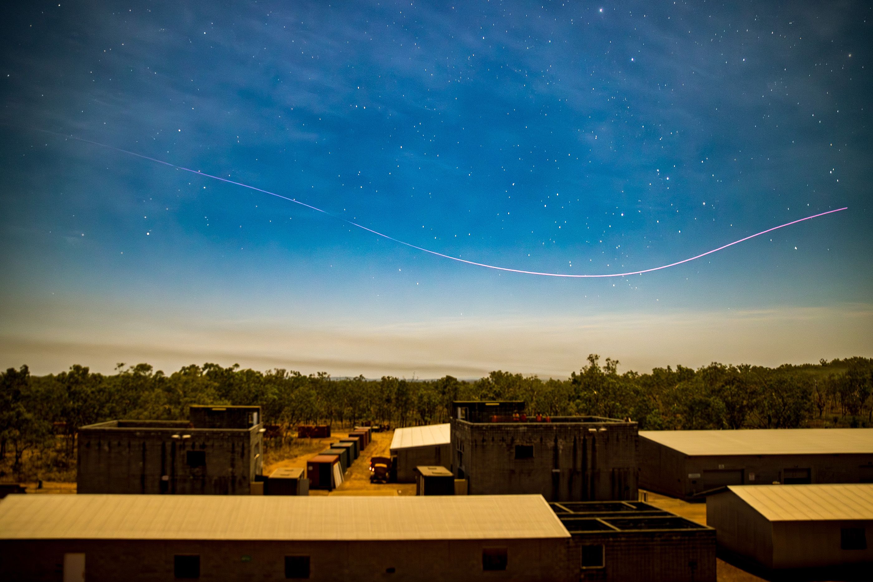 The light trail of a first-person drone sweeps over the Urban Operations Training Facility before an assault by Australian Army soldiers from the 5th/7th Battalion, Royal Australian Regiment, during Exercise Predator’s Walk at Mount Bundey Training Area, Northern Territory, June 2026.