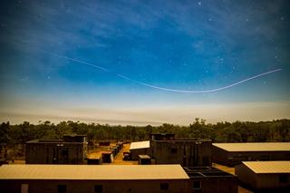 The light trail of a first-person drone sweeps over the Urban Operations Training Facility before an assault by Australian Army soldiers from the 5th/7th Battalion, Royal Australian Regiment, during Exercise Predator’s Walk at Mount Bundey Training Area, Northern Territory, June 2026.