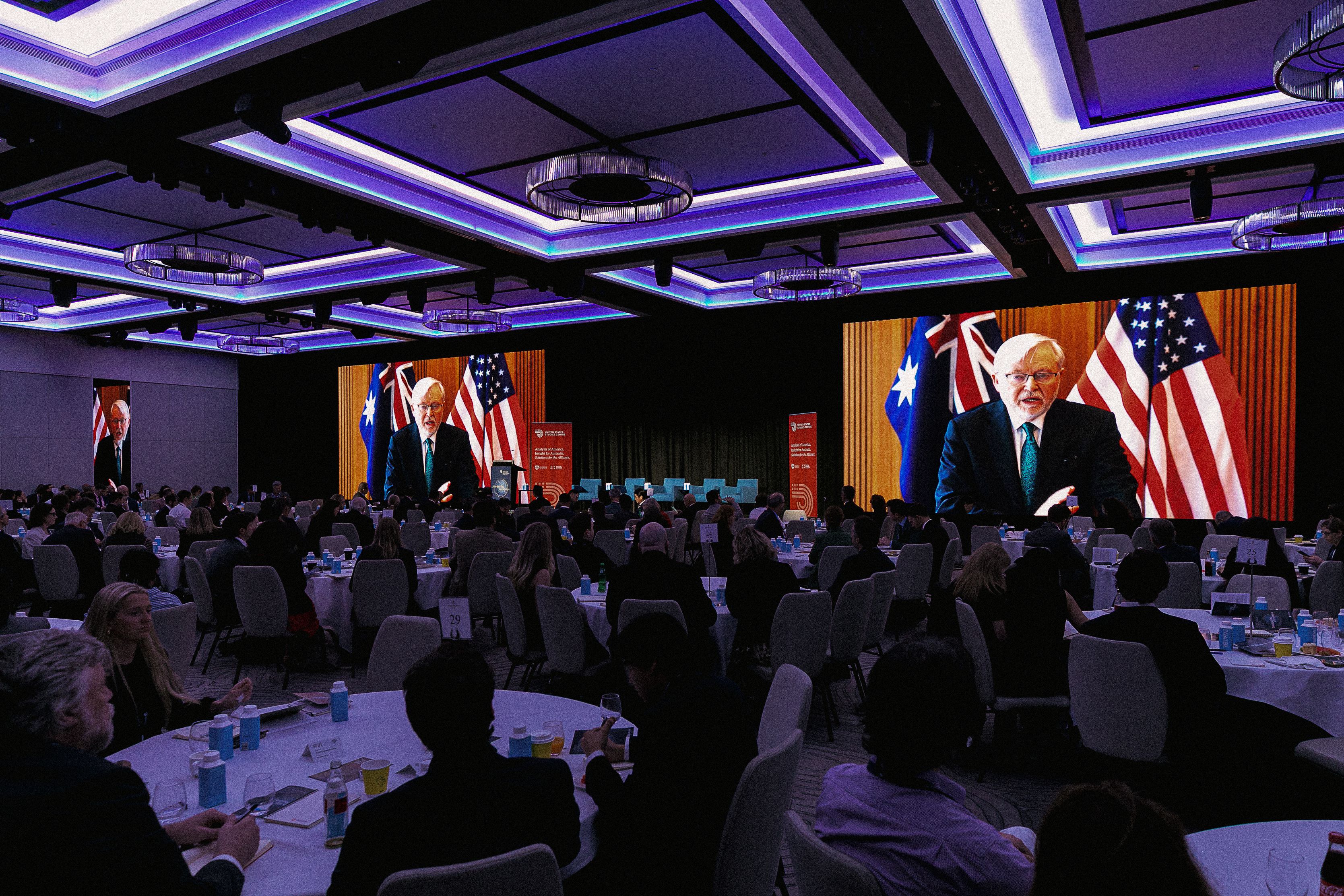 Ambassador Kevin Rudd AC speaks on screen to conference attendees.