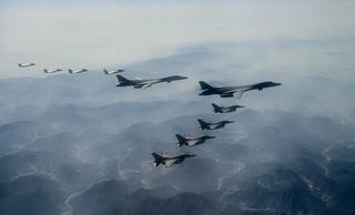 US Air Force and South Korean Air Force planes flying over land.