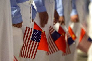 Chinese youth hold American and Chinese flags as they join officials to welcome U.S. President Donald Trump at Beijing Capital International Airport on May 13, 2026 in Beijing, China.