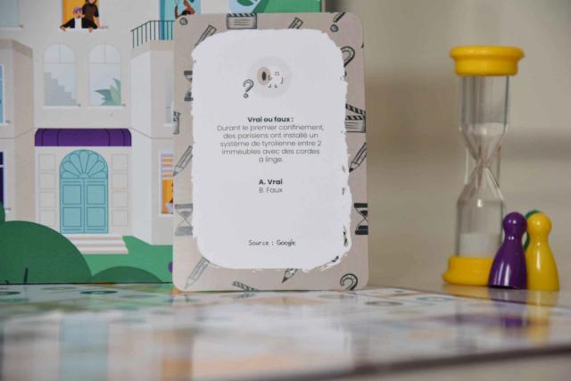 Carte « Vrai ou faux » du jeu Confin'it, devant un sablier et des pions