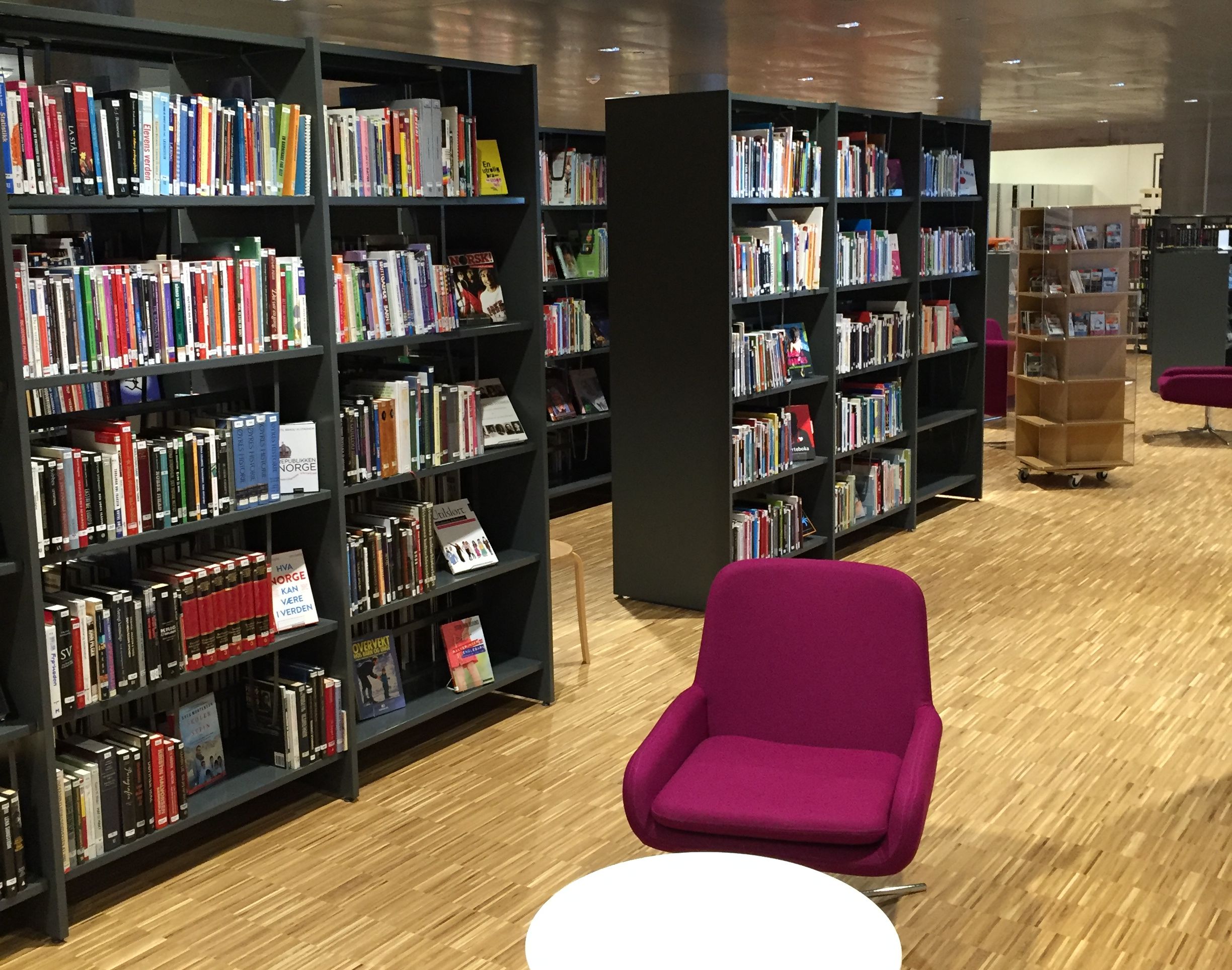 et bibliotek fylt med mange bøker og stoler